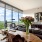 Penthouse living room with view of rolling green hills and vase of flowers