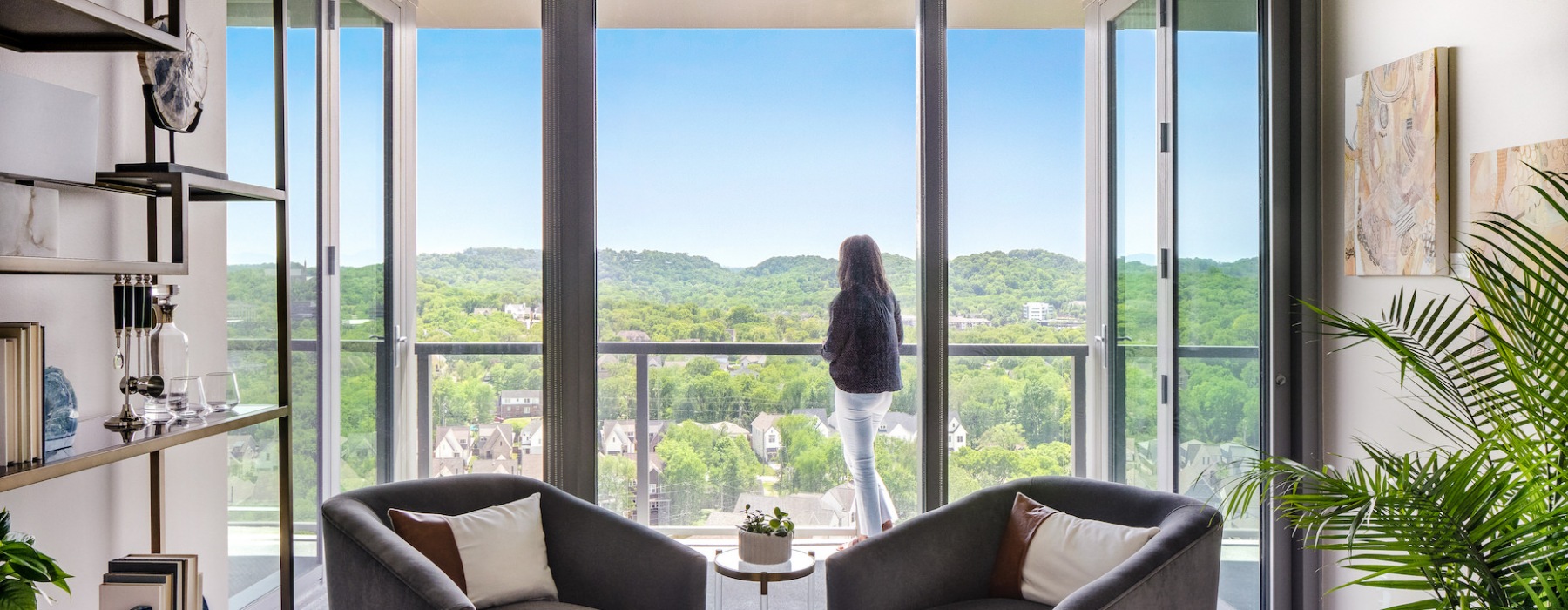 Woman overlooking landscape of green hills front penthouse