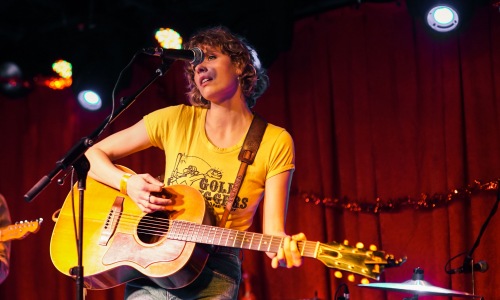 Woman playing a guitar and singing