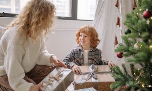 Woman and child with gifts by tree